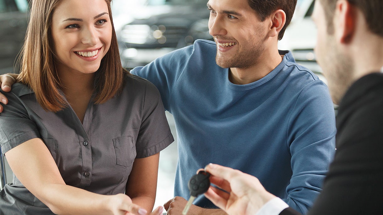 Finance manager helping a couple get approved for a vehicle