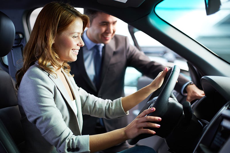 A Heritage Motors team member helping a customer behind the wheel